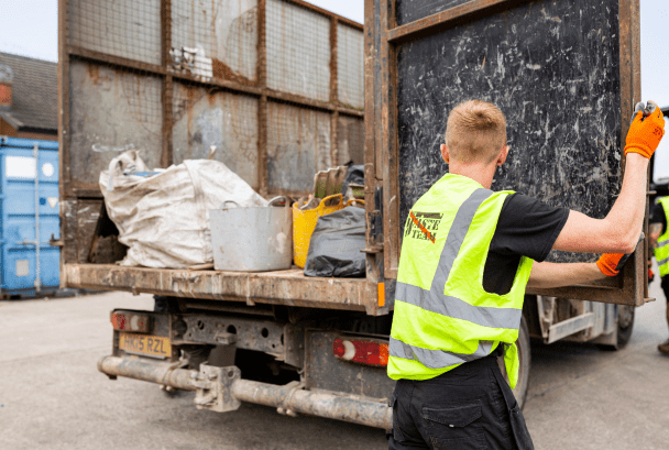 man in high vis jacket going to shut the door of a mobile waste van