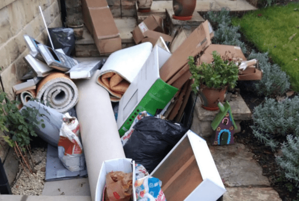 A pile of domestic waste including rolled up carpet and old furniture
