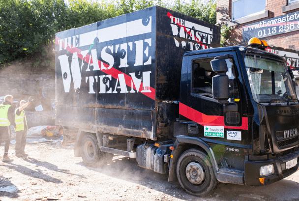 Branded The Waste Team van reversing into waste yard
