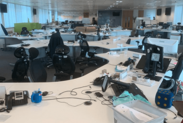 An untidy office full of desks and chairs