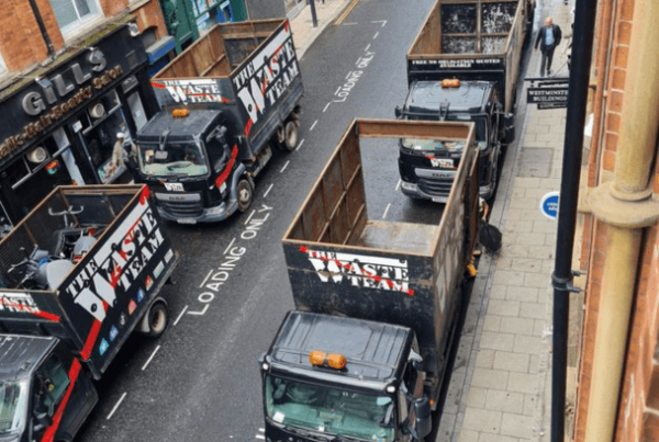 4 The Waste Team branded vans lined up on a commercial street in Leeds City Centre