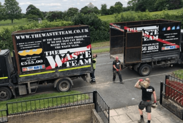 two The Waste Team branded vans outside a house with three men clearing a house of waste