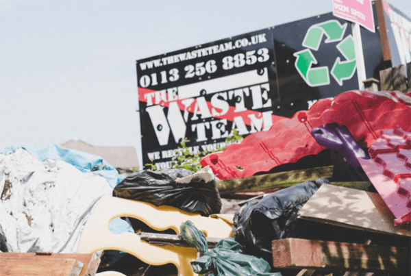 A large pile of house clearance waste and a waste disposal van