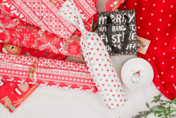 Christmas wrapping paper in red, white and green and wrapped presents on a flat surface