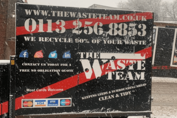 side of The Waste Team branded van with snowfall